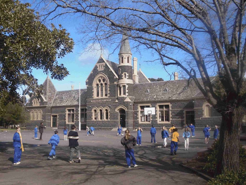 Williamstown Primary School No. 1183, Hobsons Bay Heritage Study 2006 - image shows another view of the school, framed by trees including a Moreton Bay Fig (left) and a Dutch Elm (right) along the Cecil Street frontage.
