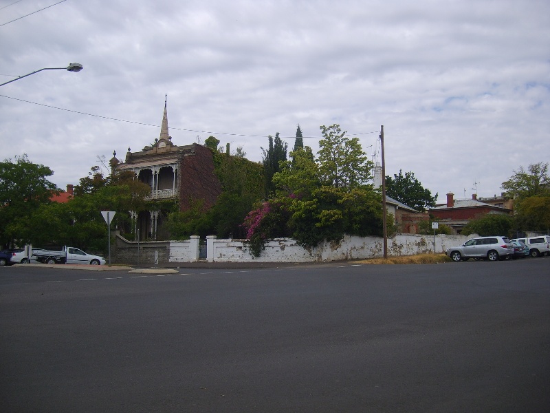 H2197 Wall associated with single story house obscured by trees