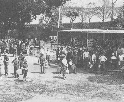 Figure 2.07: Ablutions time at the Showgrounds camp: they collected hot water in their buckets and pans from coppers in the background. Note the apparent Oak trees in the background (to the left). - Ballarat Heritage Precincts Study, 2006