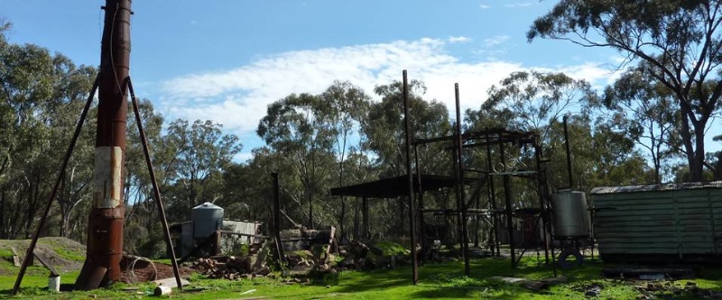 From left, looking north: Metal stack; remnants of brick boiler housing; gantry for truck-mounted vat; and rail carriage (former eucalyptus cutter's hut).