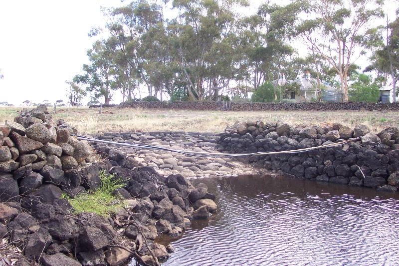 Dry stone wall dam, with cobbled ramp
