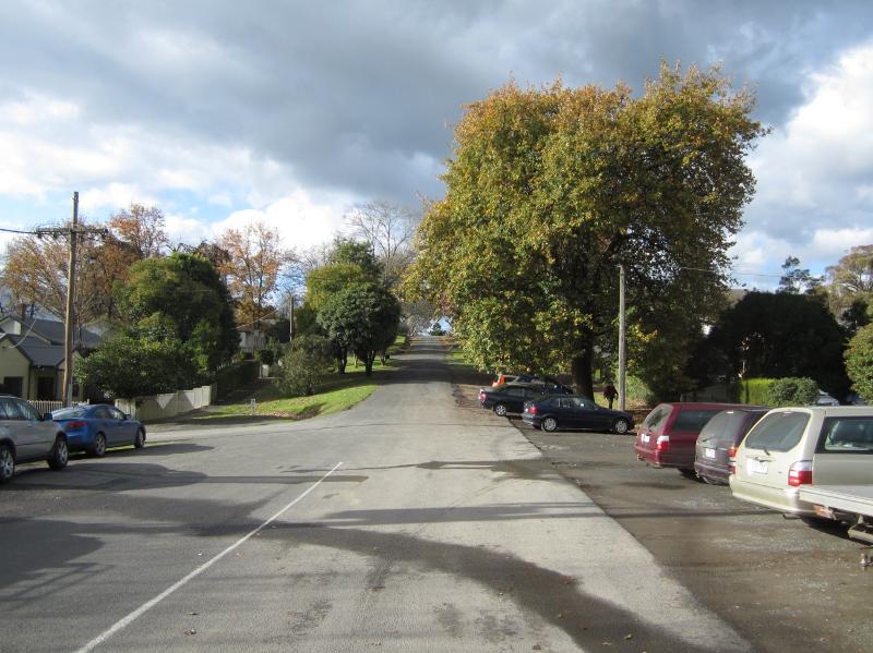 Symons St, looking east from the intersection with Crowley Rd/Green St. The street climbs towards Manse St. Note the mature trees at right.