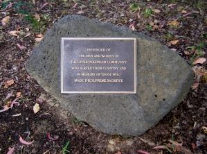 Commemorative plaque at base of Spotted Gum and Scarlet Flowering Gum trees