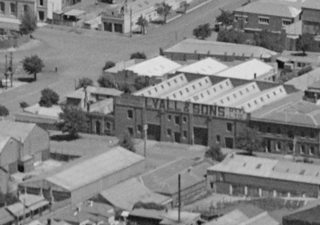 Fig 4. Corner site (Lots 1-2) (left), showing single storey masonry store on the Brougham Street frontage, rear two storey offices and modest skillion gabled outbuildings, 1938. Also note the Lyalls and Sons produce store (right)( located on lots 3-6.