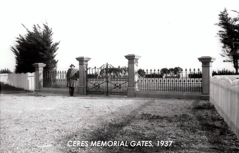 Figure 5: Ceres Memorial Gates, 1937, with Alfred Beaumont "Mont" McDowall standing. Also note the early pavilion in the background built in 1913 (left of central gate bay), gum and cypress trees forming the perimeter of the reserve &amp; the timber picke