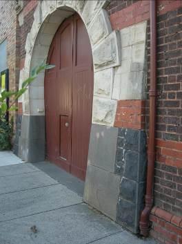 The horseshoe arch integrates limestone, trachyte and basalt with the brickwork