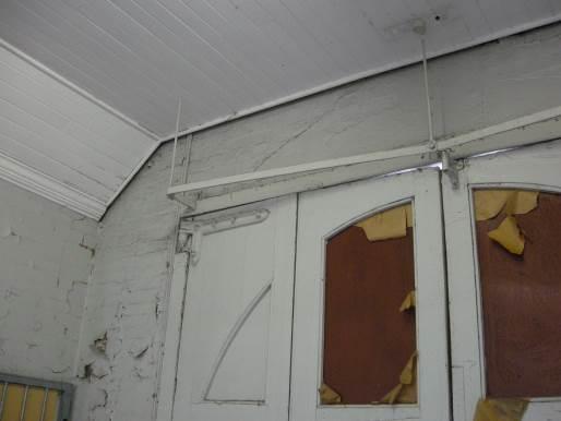 Timber-boarded ceiling junction with south and west walls inside the former fire engine room