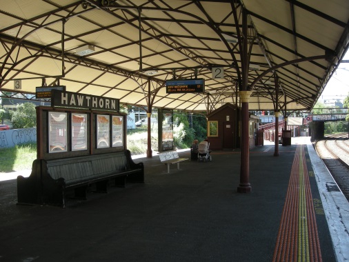 Looking north from the mid-point of the edge of Platform 2 - the Station nameboard and back-to-back timber benches in foreground are significant elements