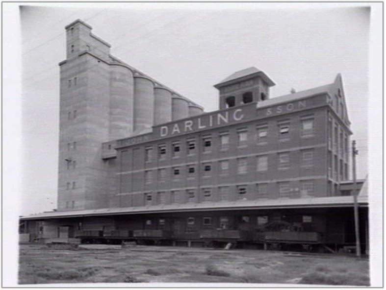 c 1940 depicting the east fa ade of the complex including the 1926-7 mill building rail siding loading platform canopy and rail cars and the 1939 concrete silos